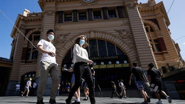 People cross a street in Melbourne on February 12, 2021, after authorities ordered a five-day state-wide lockdown starting at midnight local time to stamp out a new coronavirus outbreak. (AFP)