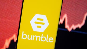 The Bumble logo is seen on a smartphone in front of a stock graph in this illustration. (Reuters)