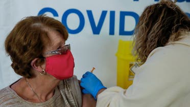 A woman receives COVID-19 vaccine at a vaccination centre in the Odeon Luxe Cinema in Maidstone, Britain February 10, 2021. REUTERS/Andrew Couldridge