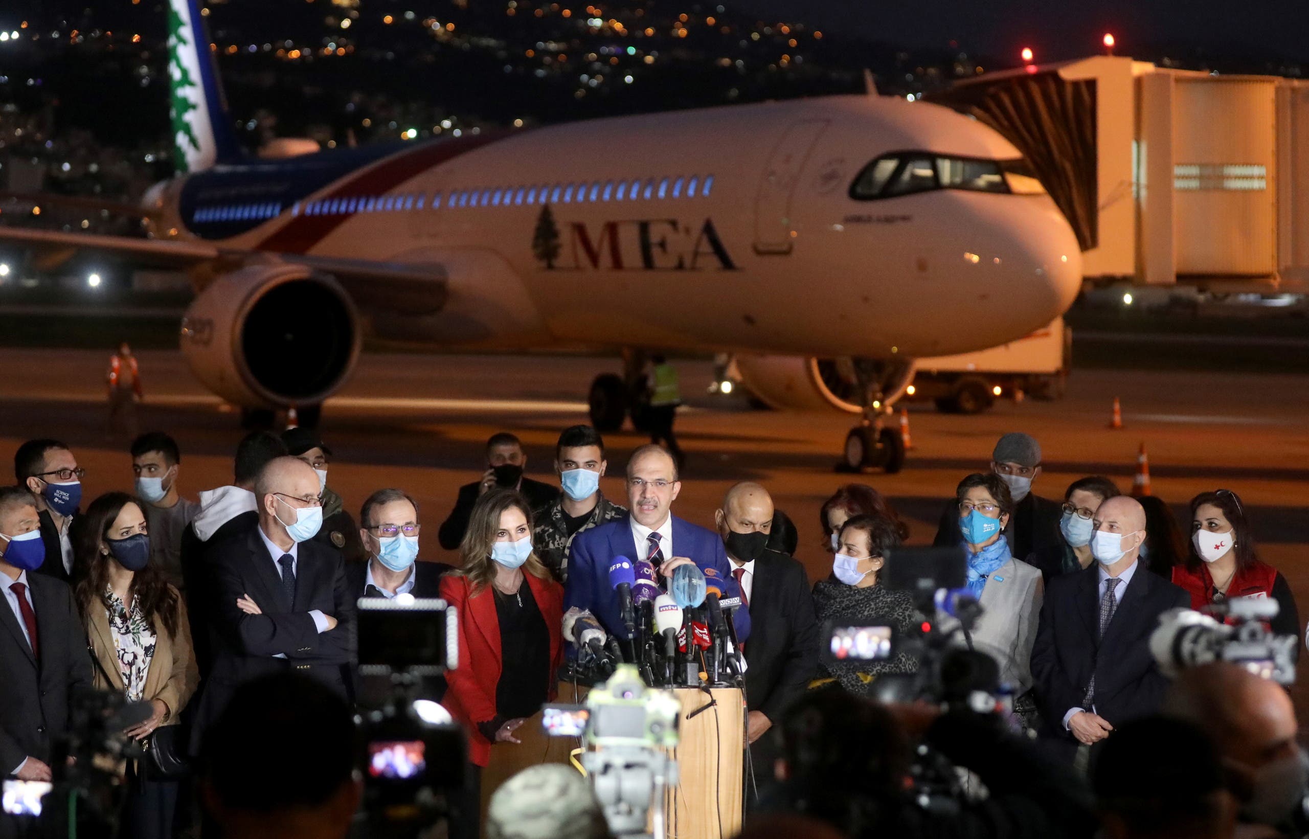 Lebanon's caretaker health minister Hamad Hasan talks near the aircraft carrying the first batch of doses of the Pfizer/BioNTech vaccine against the coronavirus disease (COVID-19) at Beirut International Airport, Lebanon February 13, 2021. (Reuters)