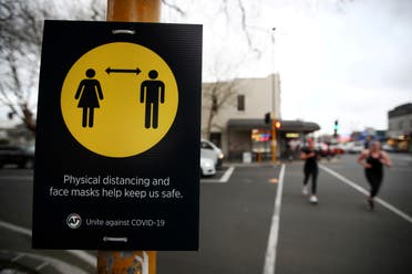 People jog past a social distancing sign on the first day of New Zealand's new coronavirus disease (COVID-19) safety measure that mandates wearing of a mask on public transport, in Auckland, New Zealand, August 31, 2020. (Reuters)