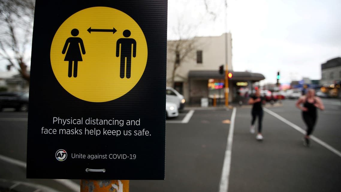 People jog past a social distancing sign on the first day of New Zealand's new coronavirus disease (COVID-19) safety measure that mandates wearing of a mask on public transport, in Auckland, New Zealand, August 31, 2020. (Reuters)
