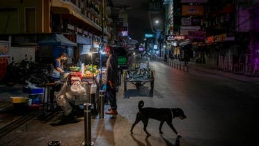 An alone street vender cooks a meal for a customer at Khao San road, a popular hangout with bars and entertainment for Thais and tourists in Bangkok, Thailand. (AP)