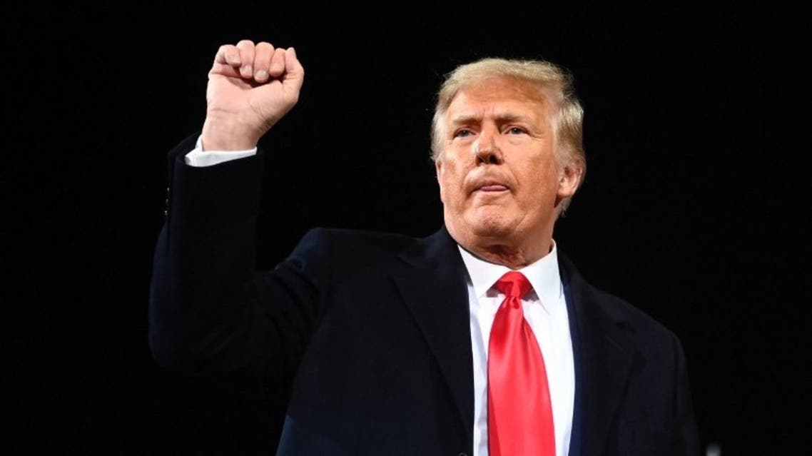 Donald Trump gestures holds up his fist after speaking during a rally to support Republican Senate candidates at Valdosta Regional Airport in Valdosta, Georgia on December 5, 2020. (AFP)