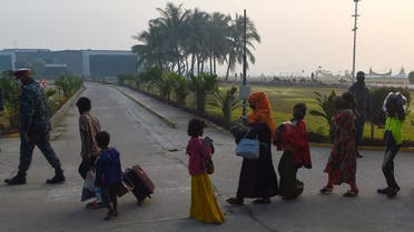 Rohingya refugees walk with their belongings in Chittagong on January 30, 2021, as they make their way to a Bangladeshi navy ship that will take them to be relocated to Bhashan Char island in the Bay of Bengal. (AFP)