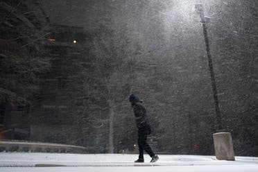 A woman walks through falling snow in San Antonio, Sunday, Feb. 14, 2021. (AP) 