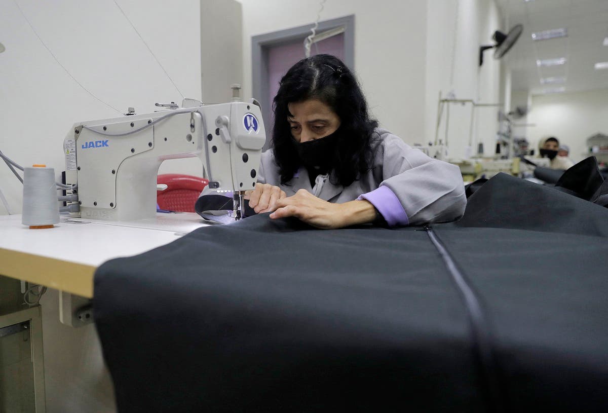Seamstresses sew body bags for COVID-19 victims at al-Oum institution sewing factory in Saida south of Beirut on February 16, 2021. (Joseph Eid/AFP)