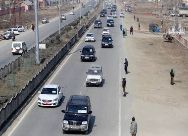 Indian policemen stand guard as a convoy carrying foreign diplomats moves on a road in Srinagar, on February 17, 2021. (Reuters)
