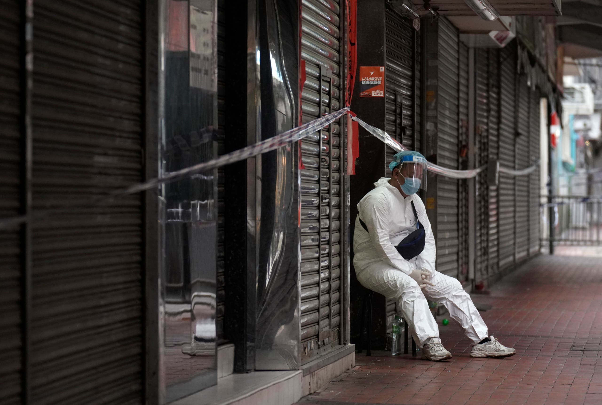 A government worker wearing personal protective equipment guards at the closed area in Jordan district, in Hong Kong, Sunday, Jan. 24, 2021. (AP)