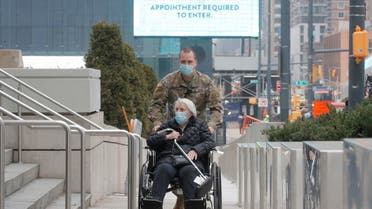 A soldier assists an elderly woman as she arrives to receive a dose of the coronavirus disease vaccine at the New York State COVID-19 vaccination site at the Jacob K. Javits Convention Center, in New York City, U.S., January 15, 2021. REUTERS/Brendan McDermid