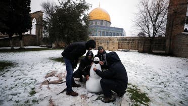 People play by the Dome of the Rock on the compound during a snowy morning in Jerusalem's Old City, February 18, 2021. (Reuters)
