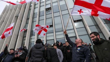 Opposition supporters wave flags following the announcement of Georgian Prime Minister Giorgi Gakharia’s resignation outside the headquarters of the United National Movement (UNM) party in Tbilisi, Georgia, on February 18, 2021. (Reuters)