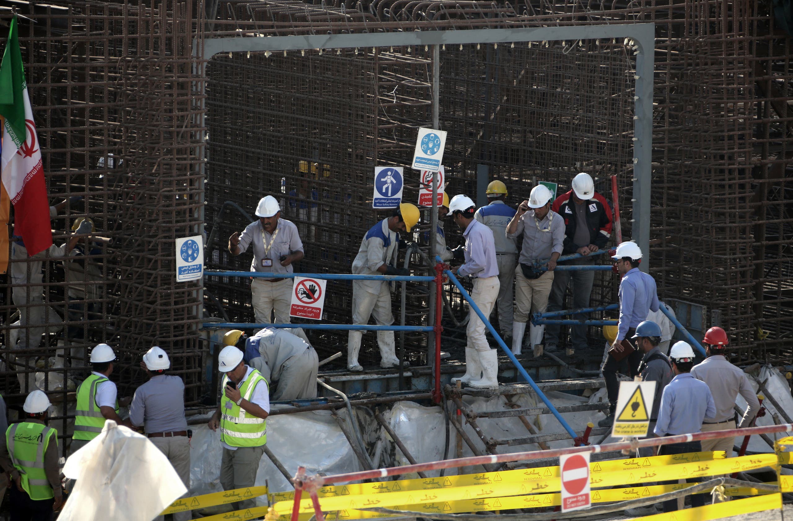 عمال عند موقع مفاعل بوشهر النووي في إيران (أرشيفية-فرانس برس)