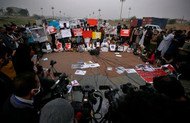  Nasrullah Baluch, center bottom, leader of the Voice of Baluch Missing Persons, speaks while people hold placards and portraits of their missing family members during a press conference in Islamabad, Pakistan, Saturday, February 20, 2021. (AP)