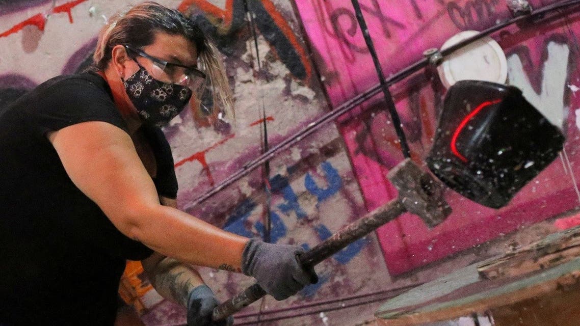 Luciana Holanda smashes a blender at the Rage Room, a place where people can destroy everyday objects to vent their anger, in Sao Paulo, Brazil, February 19, 2021. (Reuters/Carla Carniel)