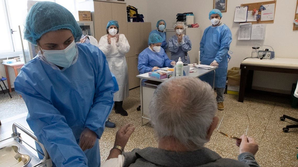 Public Health Service medical personnel applaud after an elderly man received the COVID-19 vaccine at the Don Orione rest home in Rome, Saturday, Jan. 2, 2021. (AP/Alessandra Tarantino)
