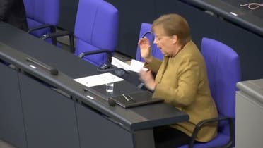 Angela Merkel panics after forgetting mask on lectern following speech. (Reuters) 