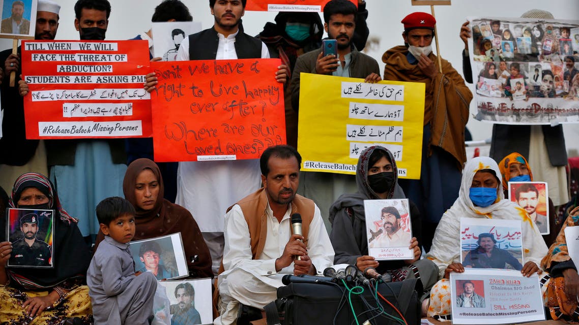 Nasrullah Baluch, center bottom, leader of the Voice of Baluch Missing Persons, speaks while people hold placards and portraits of their missing family members during a press conference in Islamabad, Pakistan, Saturday, February 20, 2021. (AP)