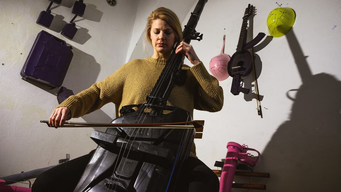 Cellist Milica Svirac plays a cello converted from a bazooka and army gas bucket, made by Serbian sculptor Nikola Macura at his studio, in Novi Sad on February 1, 2021. Macura, 42, is trying to transform these former forces of destruction into vessels of creation in a region that still bears the scars from the 1990s wars that unravelled Yugoslavia