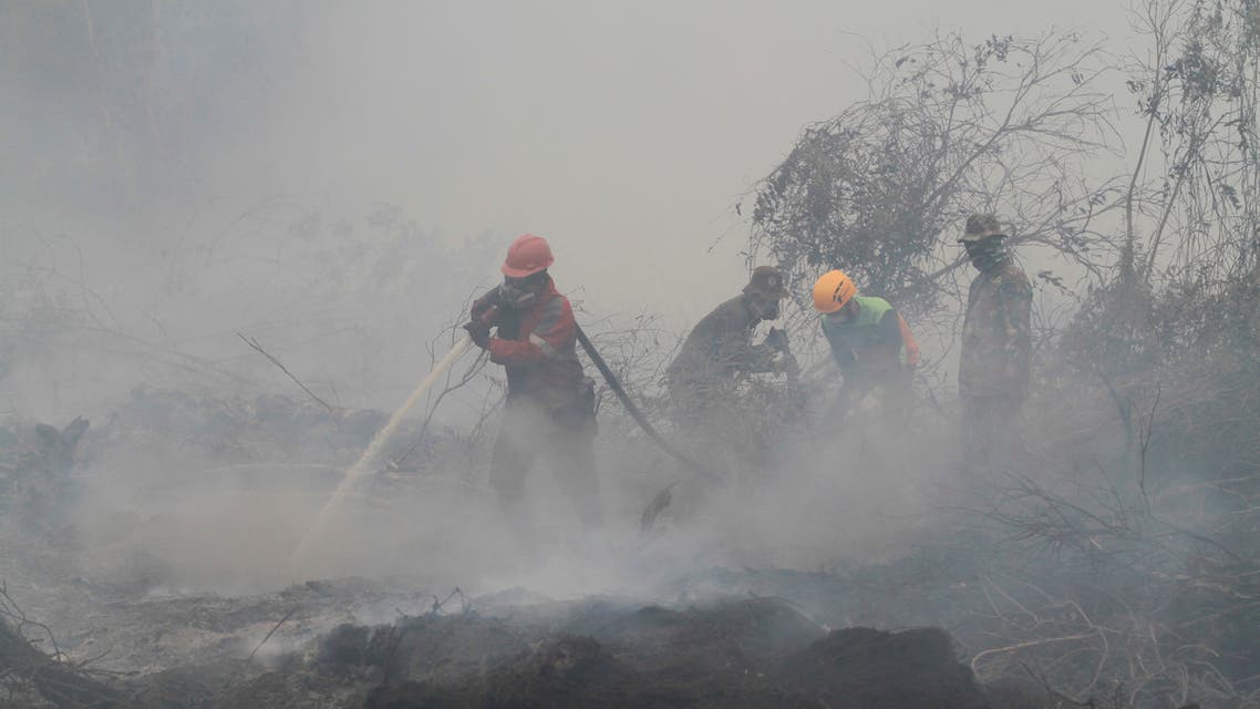 Firefighters spray water to extinguish a forest fire in Kampar, Riau province, Indonesia, Monday, Sept. 23, 2019. (AP)