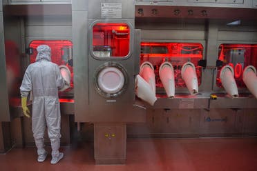 In this file photo taken on January 22, 2021, an employee in protective gear works on an assembly line for manufacturing vials of coronavirus vaccine at India’s Serum Institute in Pune. (Punit Paranjpe/AFP)