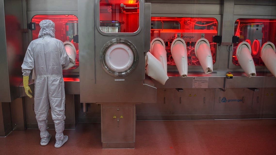 In this file photo taken on January 22, 2021, an employee in protective gear works on an assembly line for manufacturing vials of coronavirus vaccine at India’s Serum Institute in Pune. (Punit Paranjpe/AFP)
