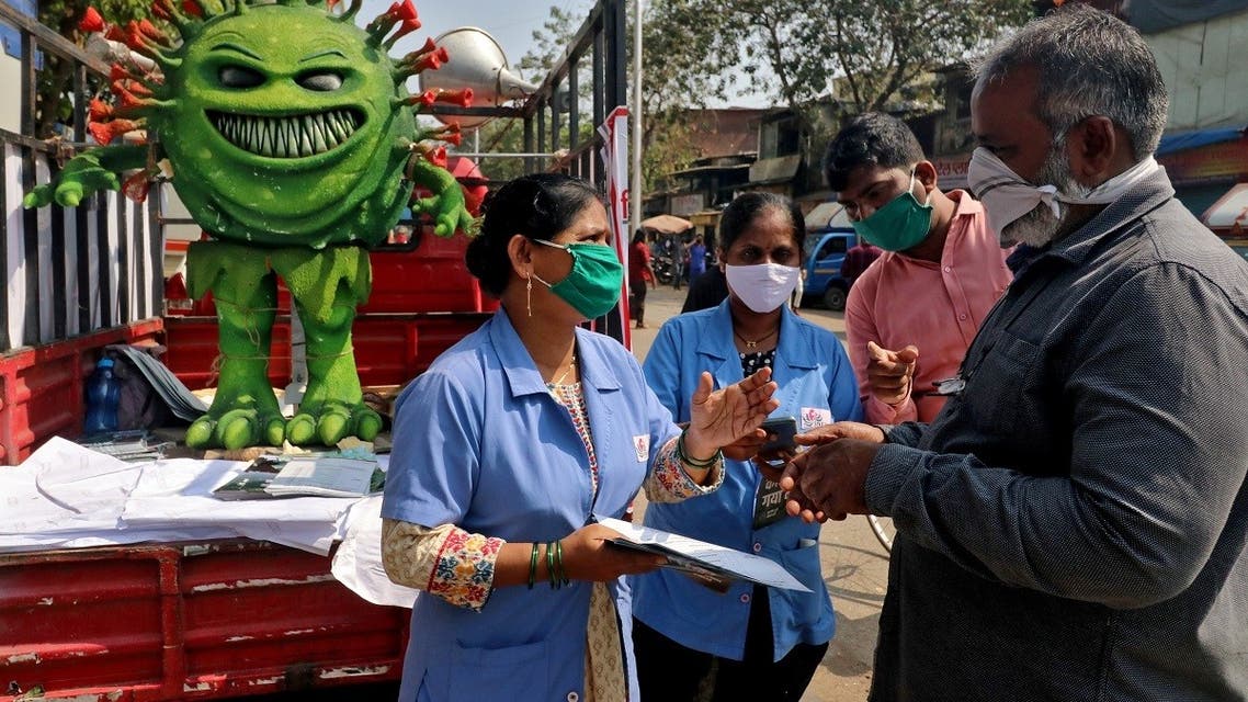 Volunteers distribute pamphlets during an awareness campaign on the spread of the coronavirus disease (COVID-19) on a street in Mumbai, India, on February 22, 2021. (Reuters)