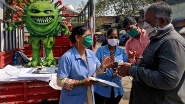 Volunteers distribute pamphlets during an awareness campaign on the spread of the coronavirus disease (COVID-19) on a street in Mumbai, India, on February 22, 2021. (Reuters)