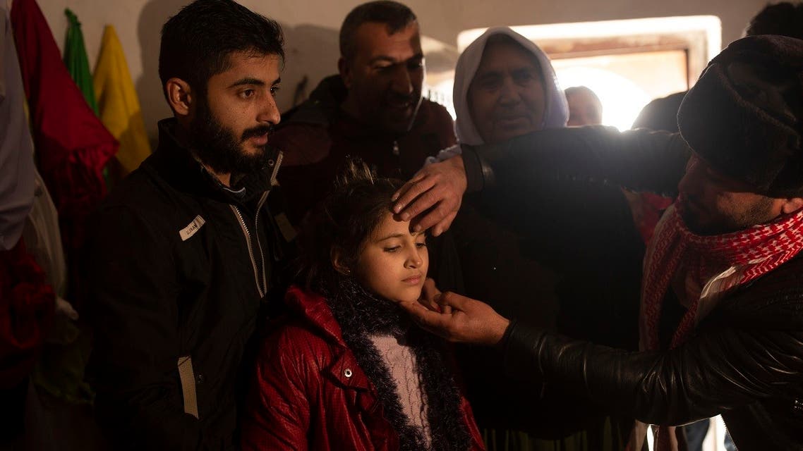 In this Feb. 12, 2020 photo, Malak Saad Dakhel, 11, is anointed by a holy man inside a Yazidi shrine as she is welcomed home by her relatives after her escape from Syria, in Sharia, Iraq. She was captured by ISIS militants in 2014 and was recently found at al-Hol camp living with a Syrian family. (AP)