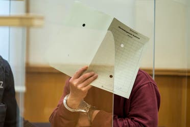 Syrian defendant Eyad Al-Gharib hides his face as he arrives to his hear his verdict in a court room in Koblenz, Germany, Wednesday, Feb. 24, 2021. (AP)