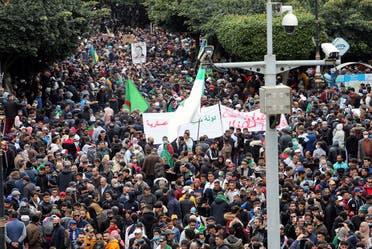 Demonstrators carry banners and flags as they march to mark the second anniversary of a mass protest movement demanding political change, in Algiers, Algeria February 22, 2021. (Reuters)