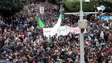 Demonstrators carry banners and flags as they march to mark the second anniversary of a mass protest movement demanding political change, in Algiers, Algeria February 22, 2021. (Reuters)