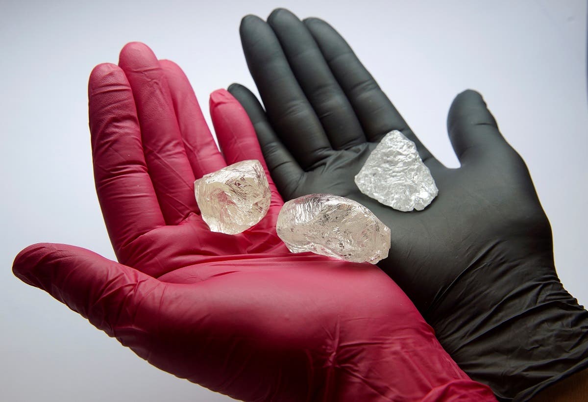 An employee shows gem-quality stones, including a rare 242-carat rough diamond that will be offered at the 100th international auction of Russian state-controlled diamond producer Alrosa, during a presentation in Moscow, Russia, on February 25, 2021. (Reuters)