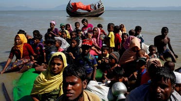 Rohingya refugees sit on a makeshift boat as they get interrogated by the Border Guard Bangladesh after crossing the Bangladesh-Myanmar border, at Shah Porir Dwip near Cox’s Bazar, Bangladesh. (Reuters)