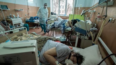 A nurse walks between patients with coronavirus at an intensive care unit in the regional hospital in Chernivtsi, western Ukraine, Wednesday, Feb. 24, 2021. The number of coronavirus cases in the western part of the country has risen sharply since the end of a strict two-week lockdown last month. (AP Photo/Evgeniy Maloletka)