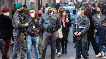 Security forces patrol as people wearing protective masks walk along the principal shopping street of Via del Corso, amidst the coronavirus outbreak, Rome, Italy, February 27, 2021. (Reuters/Remo Casilli)