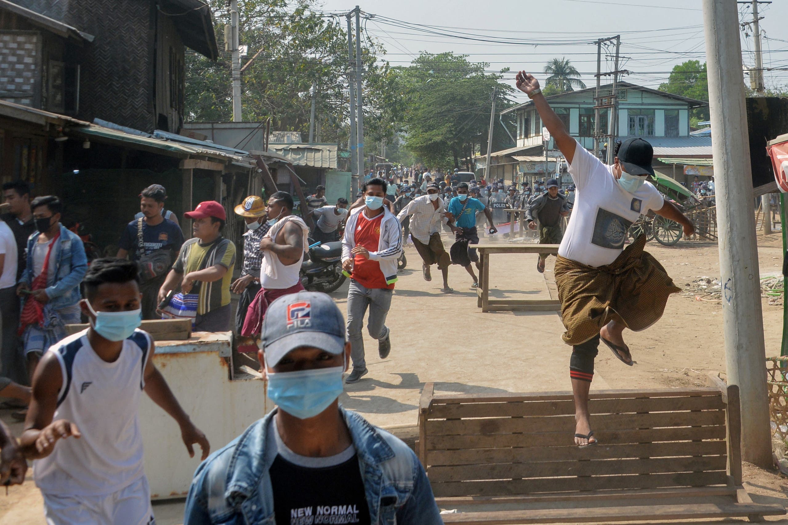 متظاهرون ضد الاانقلاب يفرون من الشرطة في إحدى مدن ميانمار أمس الجمعة