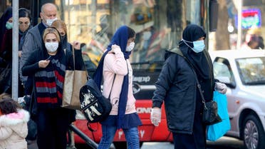 Iranians wearing protective masks amid the COVID-19 pandemic, leave a bus in the capital Tehran, on December 30, 2020. (Atta Kenare/AFP)