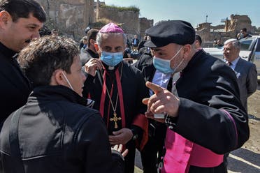 Archbishop of the Archeparchy of Mosul Najib Mikhael Moussa (C) and Father Raed Adel (L) listen to the members of the Papal convoy during their visit to Iraq’s northern city of Mosul, February 23, 2021. (Zaid al-Obeidi/AFP)
