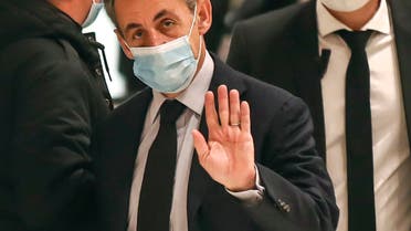Former French President Nicolas Sarkozy waves to the media as he arrives at the courtroom in Paris, Friday, Dec. 10, 2020. (AP)