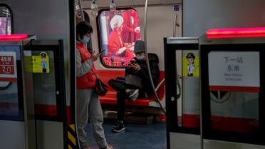 Commuters wearing face masks to help curb the spread of the coronavirus browse their smartphones inside a subway train in Beijing Wednesday, Feb. 10, 2021. (AP)