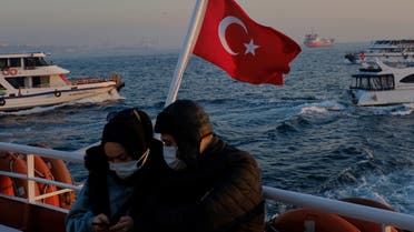 A couple wearing protective masks travel on a ferry over the Bosphorus, amid the coronavirus disease (COVID-19) outbreak in Istanbul, Turkey February 23, 2021. (Reuters/Murad Sezer)