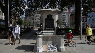 In this file photo dated Monday, June 8, 2020, people walk past the empty plinth after a statue of notorious slave trader Edward Colston was pulled down during a Black Lives Matter demo, in Bristol, England. (File photo: AP)