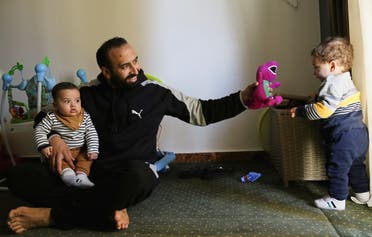 Mohamed Abdallah holds his biological son Soliman as he plays with Dawood, an orphan he sponsors, in their home in Cairo, Egypt February 24, 2021. Picture taken February 24, 2021. (Reuters/Hanaa Habib)