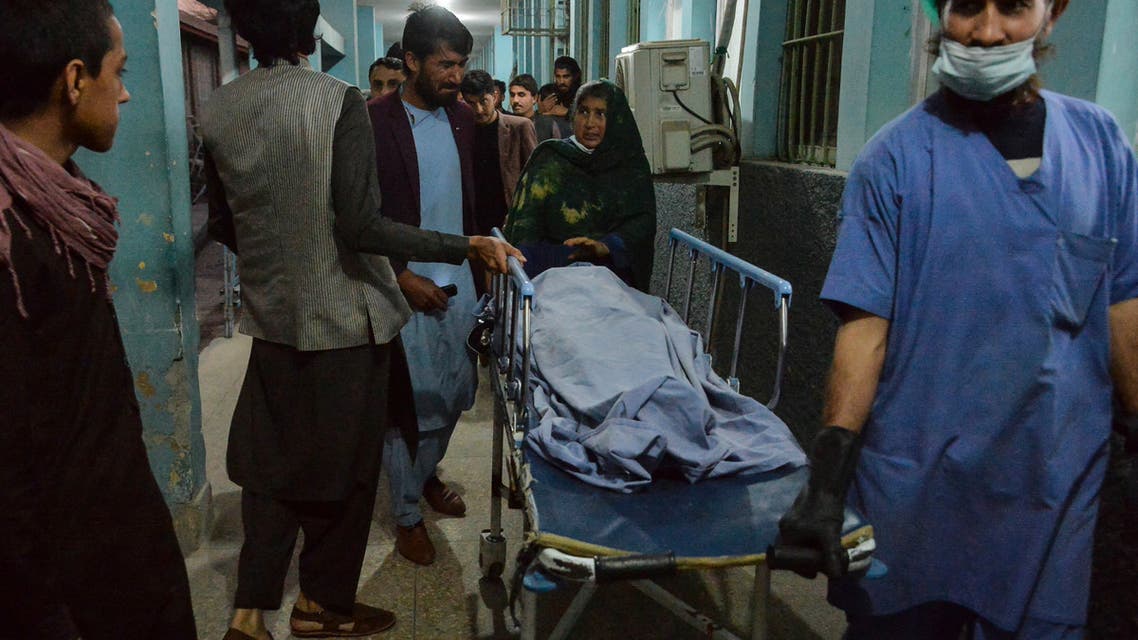 Hospital workers and relatives shift the body of one of the three female media workers shot to death in two separate attacks, at a hospital in Jalalabad on March 2, 2021. (AFP)