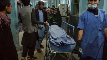 Hospital workers and relatives shift the body of one of the three female media workers shot to death in two separate attacks, at a hospital in Jalalabad on March 2, 2021. (AFP)