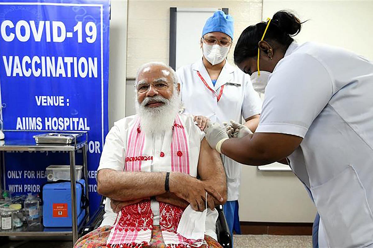 In this handout photograph taken on March 1, 2021 and released by the Indian Press Information Bureau (PIB), a health worker inoculates India's PM Modi (L) with COVAXIN coronavirus vaccine at AIIMS hospital in New Delhi. (PIB/AFP)