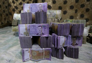 Stacks of Syrian pounds are pictured inside an exchange currency shop in Azaz, Syria, on February 3, 2020. (Reuters)