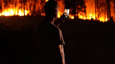 A man takes photos of a fire outside the village of Roqueiro, near Oleiros, Portugal, Monday, Sept. 14, 2020. (File photo: AP)