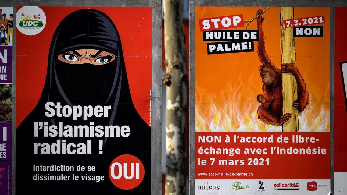 A photograph taken on March 1, 2021 in Geneva shows two campaign posters, one in favour of a burqa ban (L) initiative reading in French: Stop Radical Islamism! and the other (R) against a free trade agreement with Indonesia reading in French: Stop palm oil! No to the free trade agreement with Indonesia on March 7, 2021 ahead of a nationwide vote by Swiss citizen. (AFP)